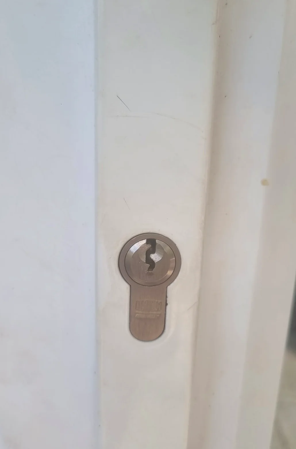 Euro cylinder fitted in a white door handle plate