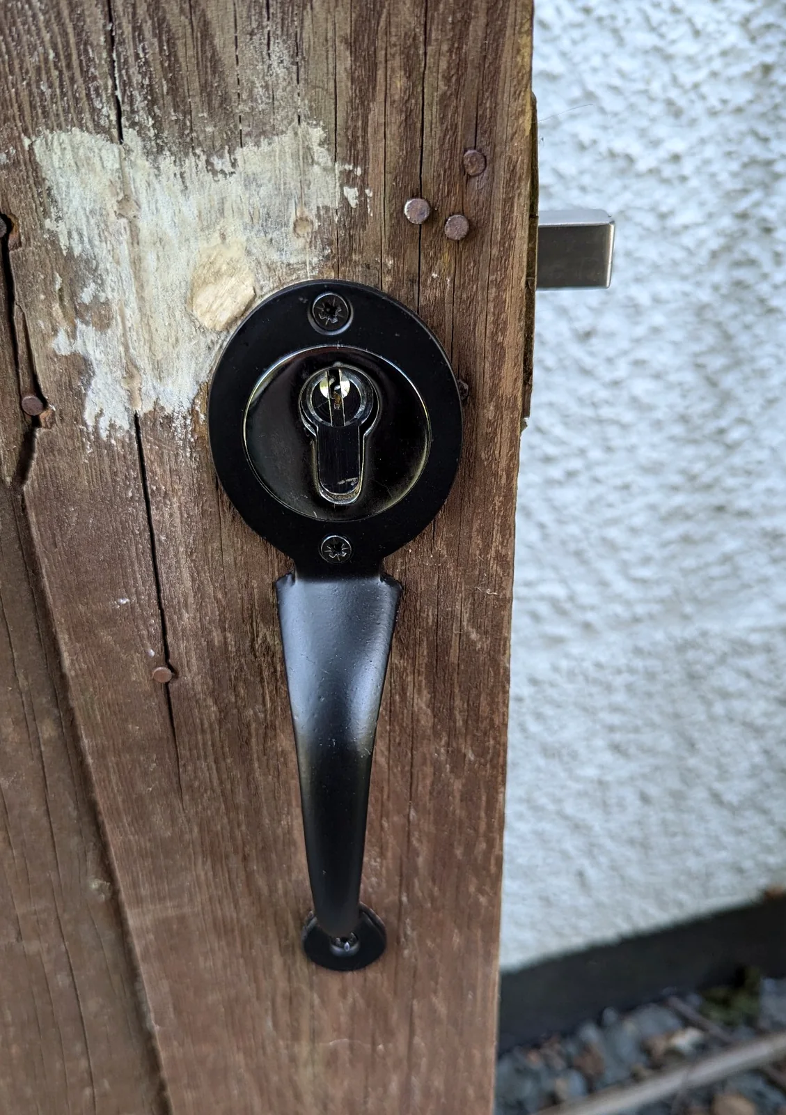 Black gate handle and cylinder fitted to a timber gate