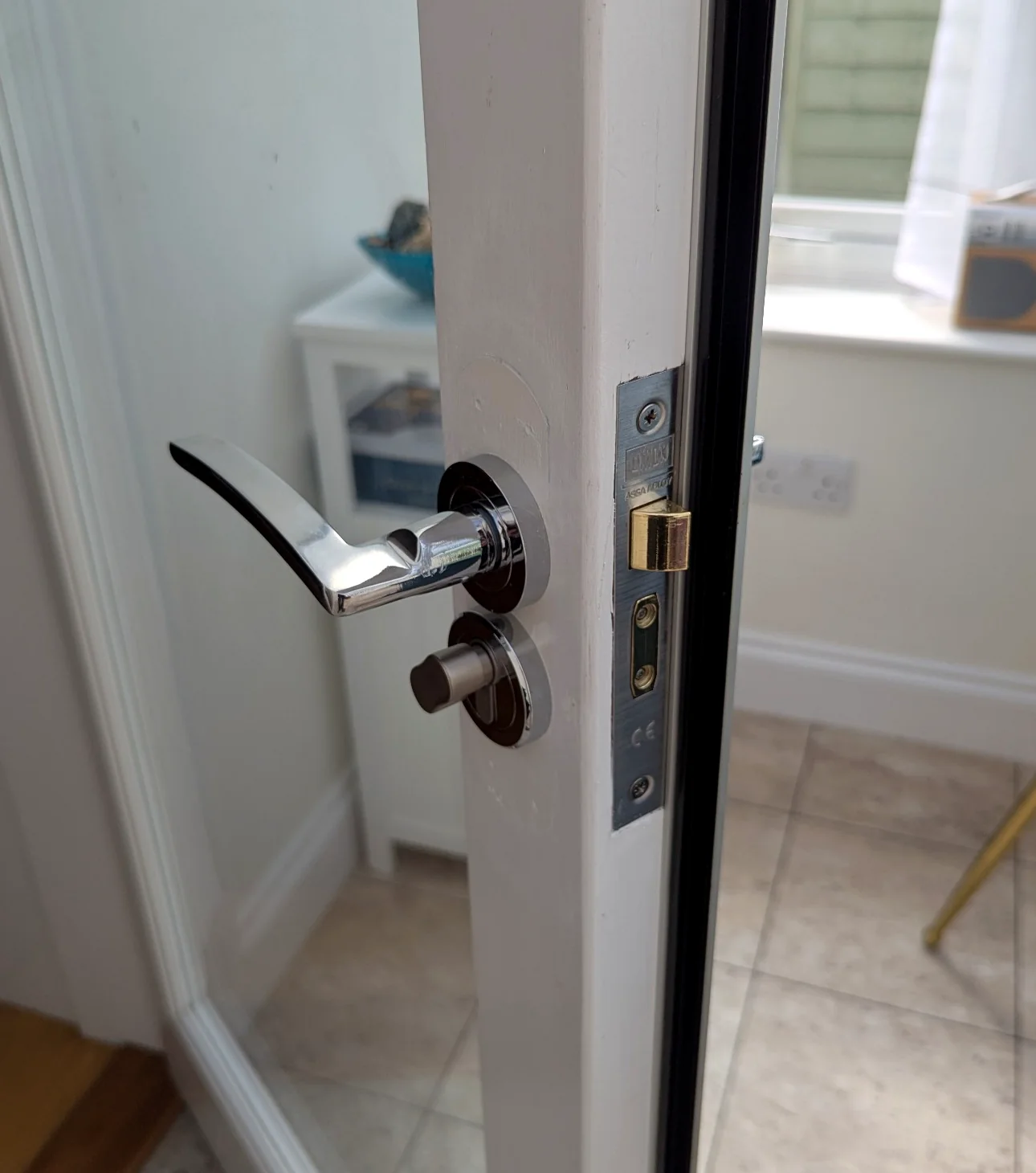 Internal white door with handle and lock mechanism being worked on