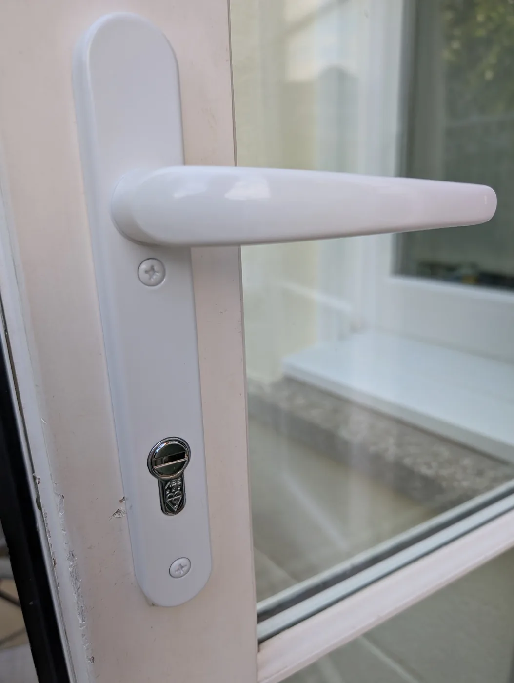 Maximum security cylinder upgrade fitted in a white door handle plate