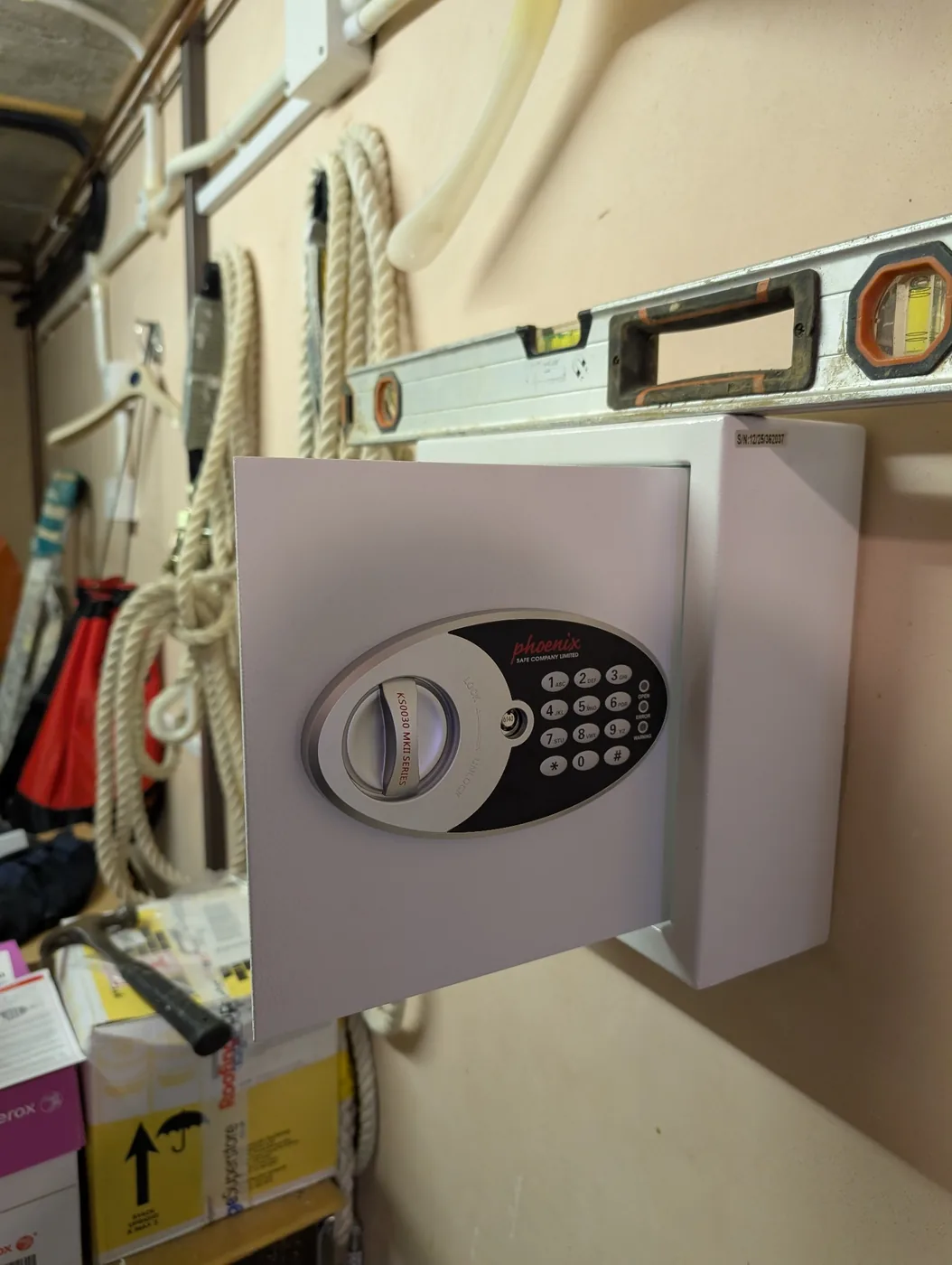 Small wall-mounted security safe fitted level in a storage area